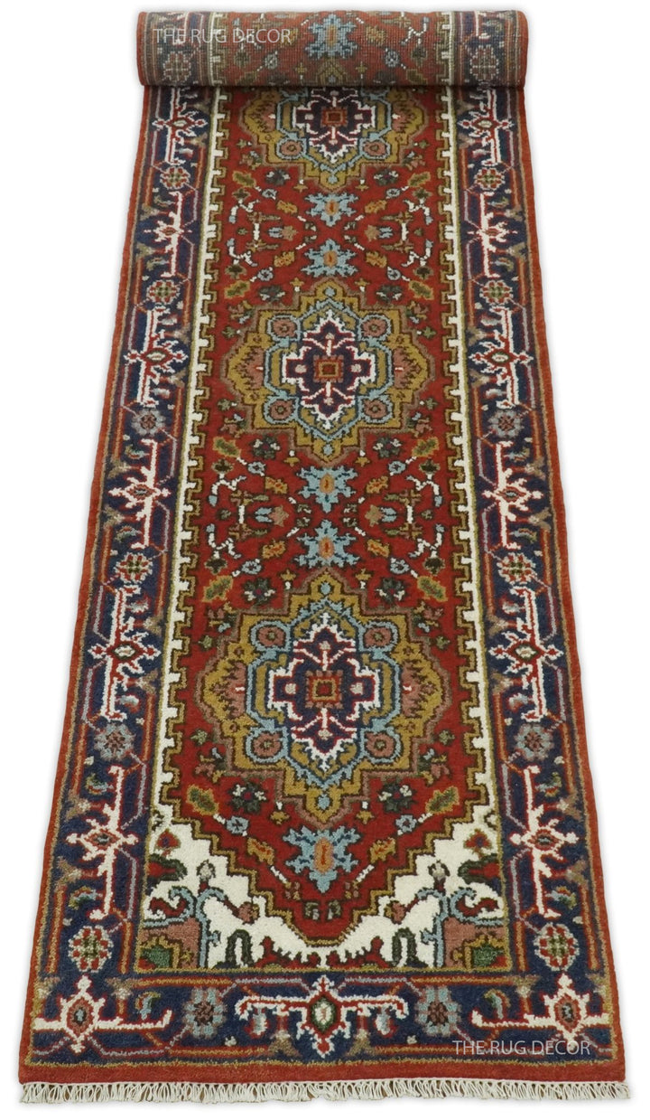 Wool runner rug partly rolled, with rust field, blue borders, and fringed edge