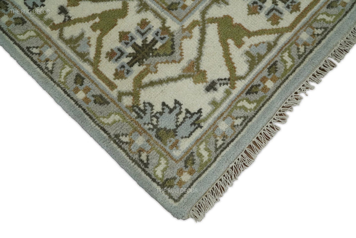 Rug corner showing ivory fringe, bluish silver binding, and ornate floral border