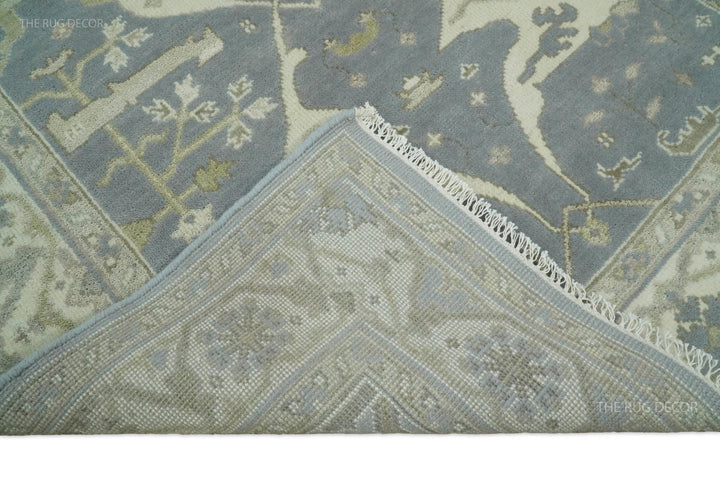 Ruled corner detail of blue-gray and ivory rug with decorative border and fringe.