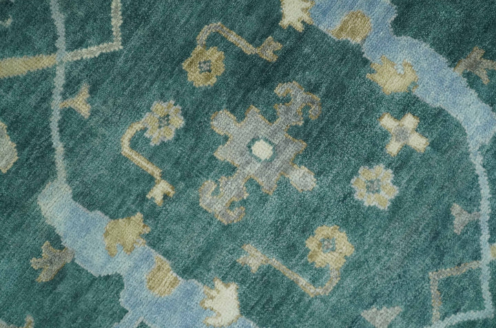 Close-up of teal and beige Oushak rug pattern with small cross and diamond motifs.