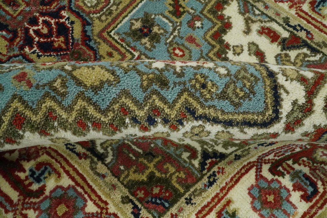Close-up of rug texture with teal blue vine and geometric motifs on ivory background