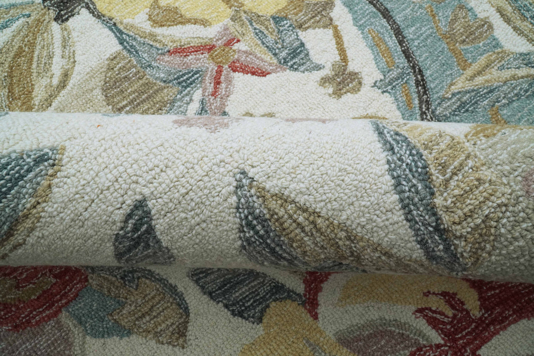 Close-up tufted wool rug showing layered leaves and flowers with speckled texture