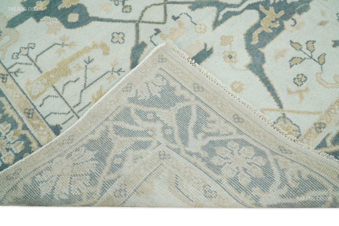 Close-up teal and ivory Oushak wool rug with bordered diamond motif