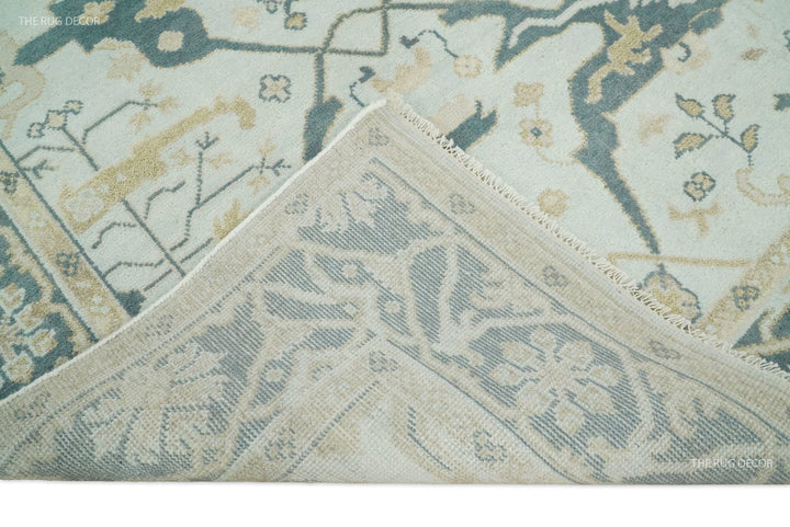 Close-up teal and ivory Oushak wool rug with bordered diamond motif