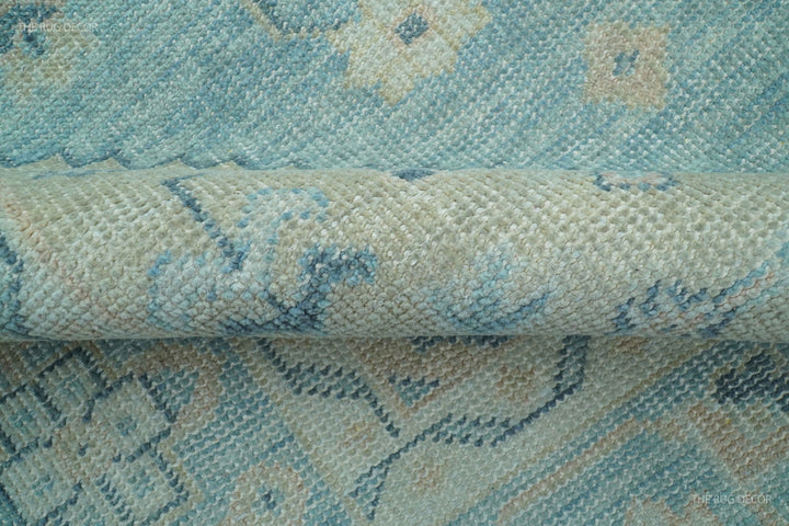 Hand-knotted wool rug edge with short fringe and blue-beige woven pattern