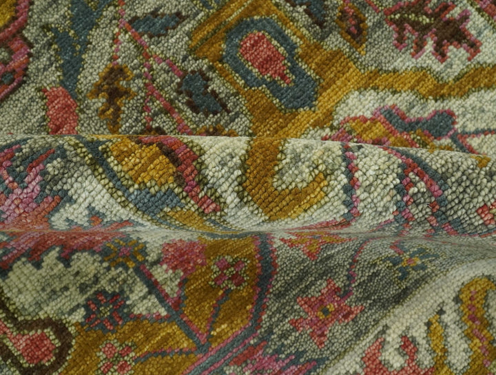 Hand-knotted wool rug close-up with muted teal, mustard, and rust pattern blocks