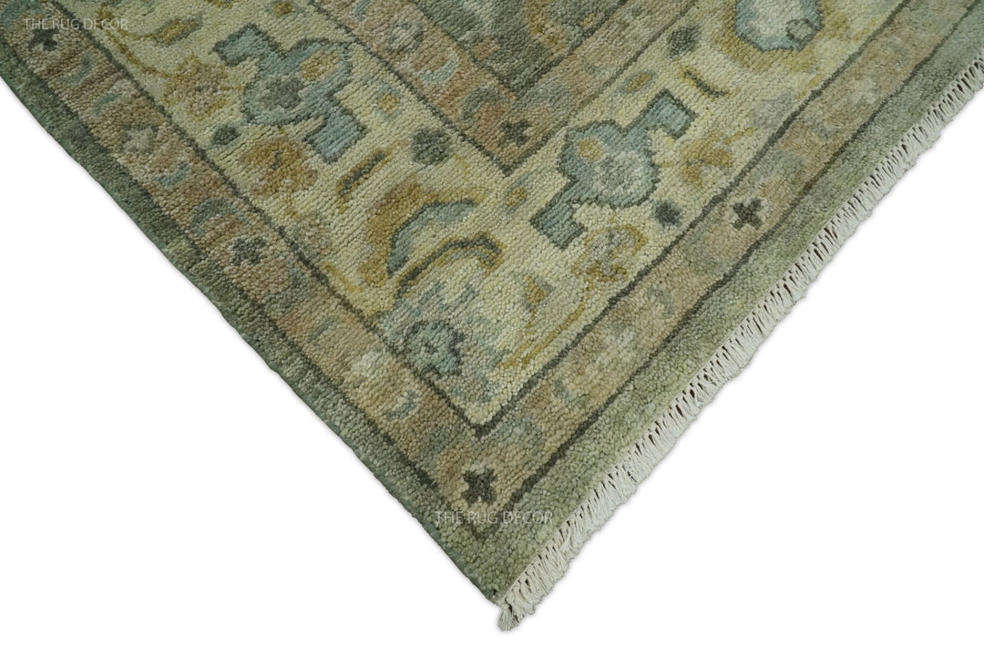 Corner of vintage Turkish-style wool rug in gray-green with beige and teal motif details