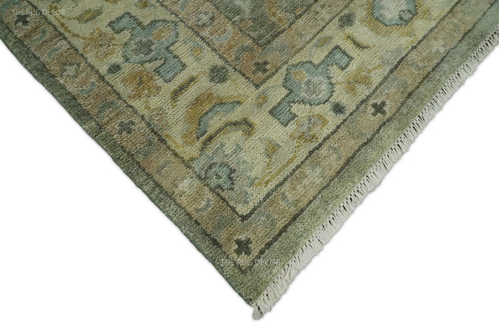 Corner of vintage Turkish-style wool rug in gray-green with beige and teal motif details