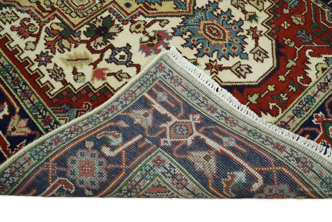 Hand-knotted wool rug edge and corner, decorative pattern in navy, teal, green, and maroon