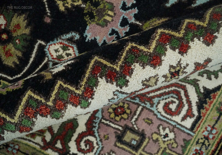 Hand-knotted wool rug close-up showing floral and vine motifs in cream, red, and green