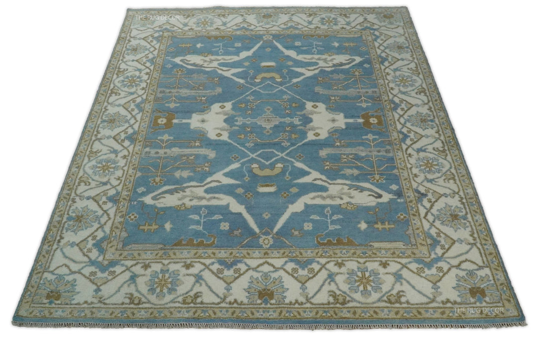 Blue and ivory Oushak wool rug shown from the front, with a central medallion and floral border