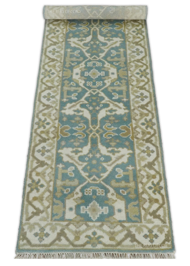 Teal and ivory patterned runner rug with a folded end and fringe