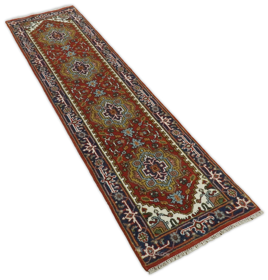 Angled view of the long rust and blue floral runner rug with fringed ends