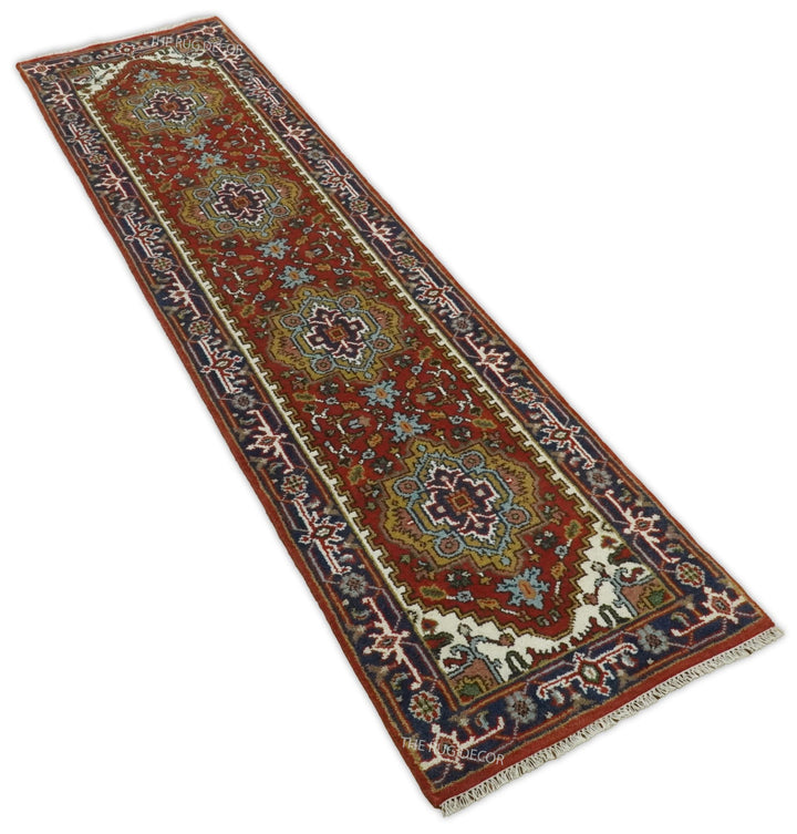 Angled view of the long rust and blue floral runner rug with fringed ends