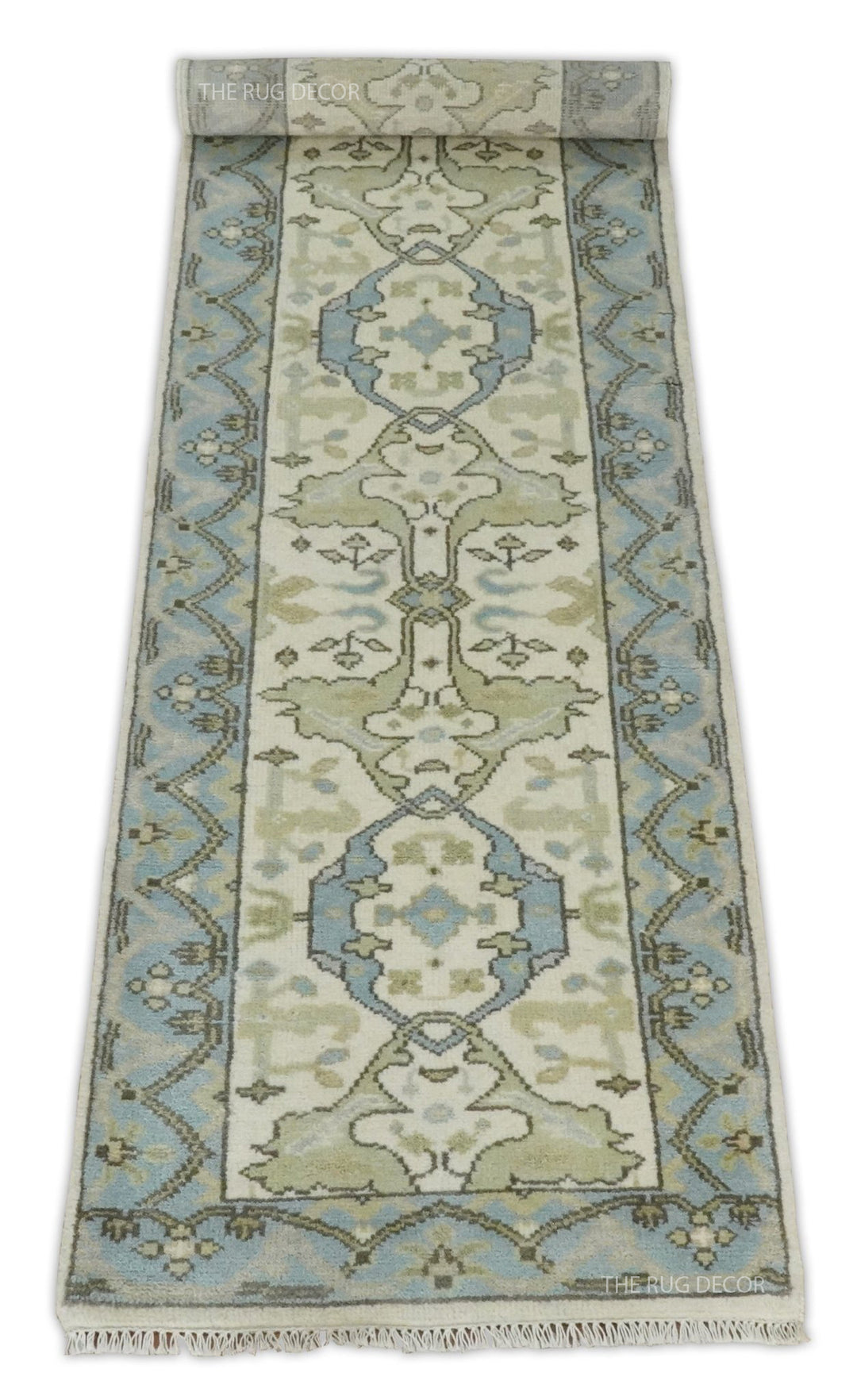 Ivory and blue runner rug with one end rolled to display its pattern