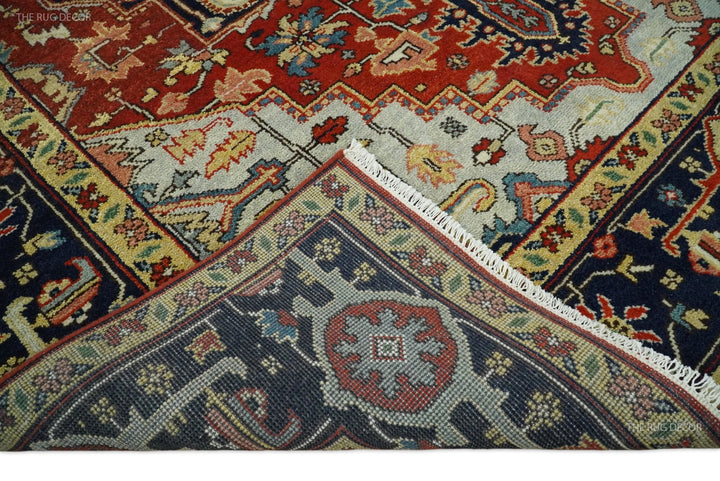 Close-up edge of red and blue hand-knotted wool rug with patterned border and fringe