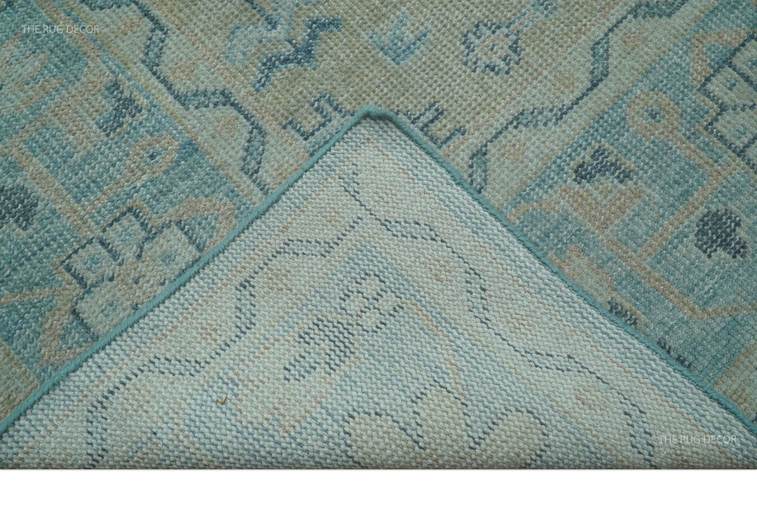 Close-up corner of hand-knotted wool rug with blue and beige geometric border