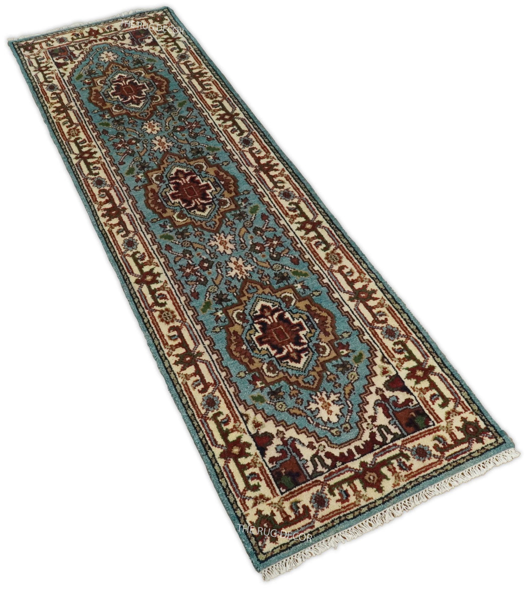 Angled view of a blue and ivory runner rug with three floral medallions