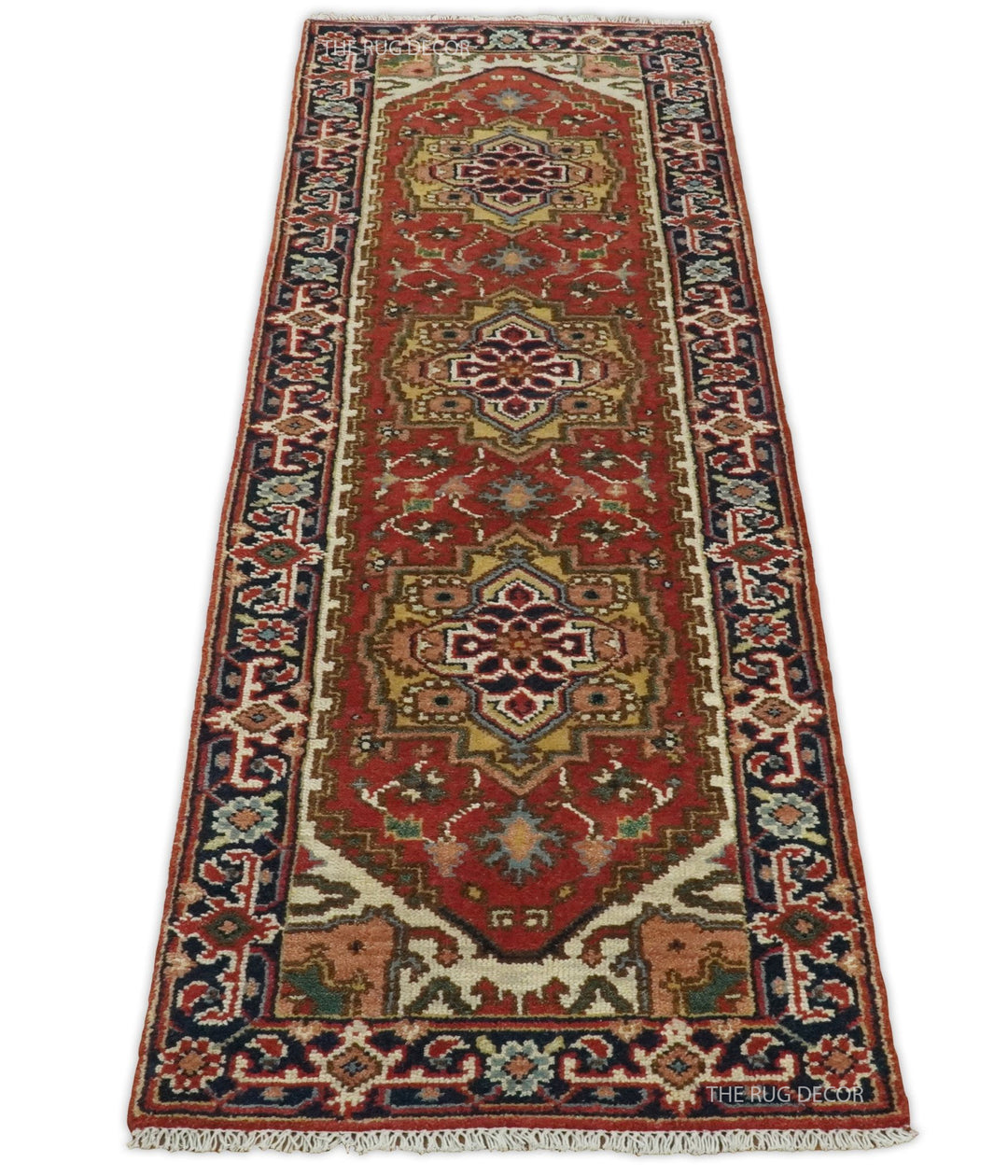 Full view of the runner rug's rust ground, three medallions, blue borders, and fringed end