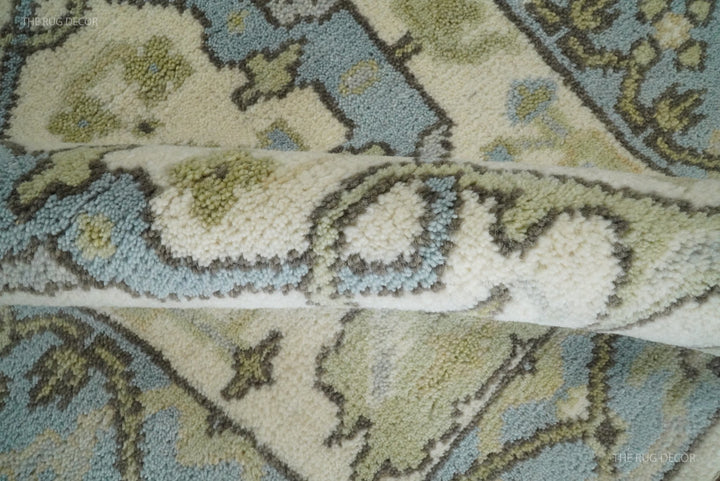 Folded edge reveals the thick pile of the ivory and blue wool runner rug