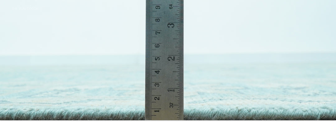 Hand-knotted wool area rug shown with ruler measuring short pile height