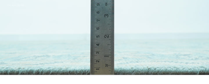 Hand-knotted wool area rug shown with ruler measuring short pile height