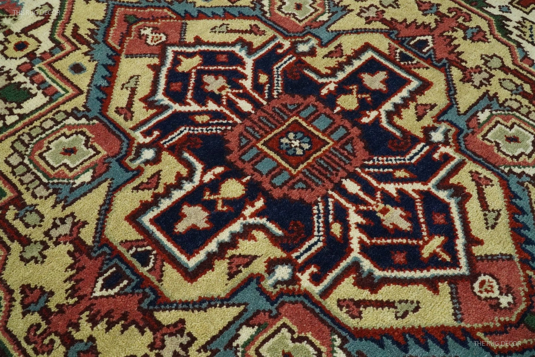 Hand-knotted wool rug close-up with central dark-blue medallion on ivory and maroon ground