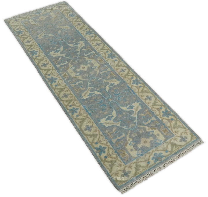 Angled view of a gray and beige runner rug with blue motifs and fringed ends