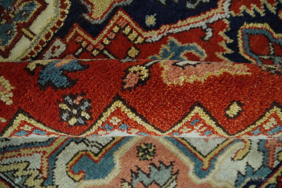 Texture detail of red, navy, and cream medallion pattern on hand-knotted wool rug