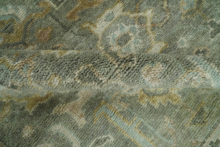 Close-up of textured rug pile with tonal gray-green and beige geometric designs