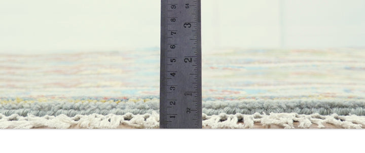 Round multicolor wool rug edge with short fringe and visible pile height measurement