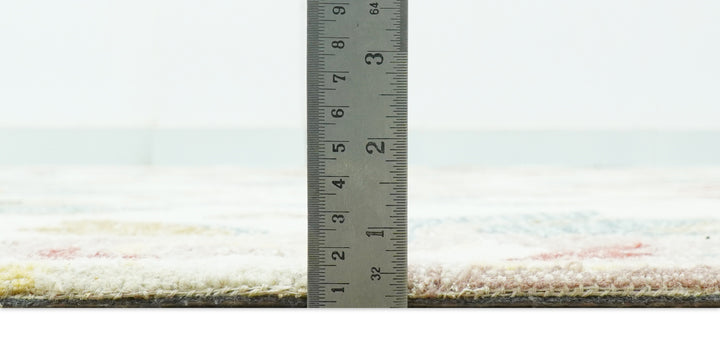 Rug thickness measurement with a ruler along the edge of the floral tufted surface