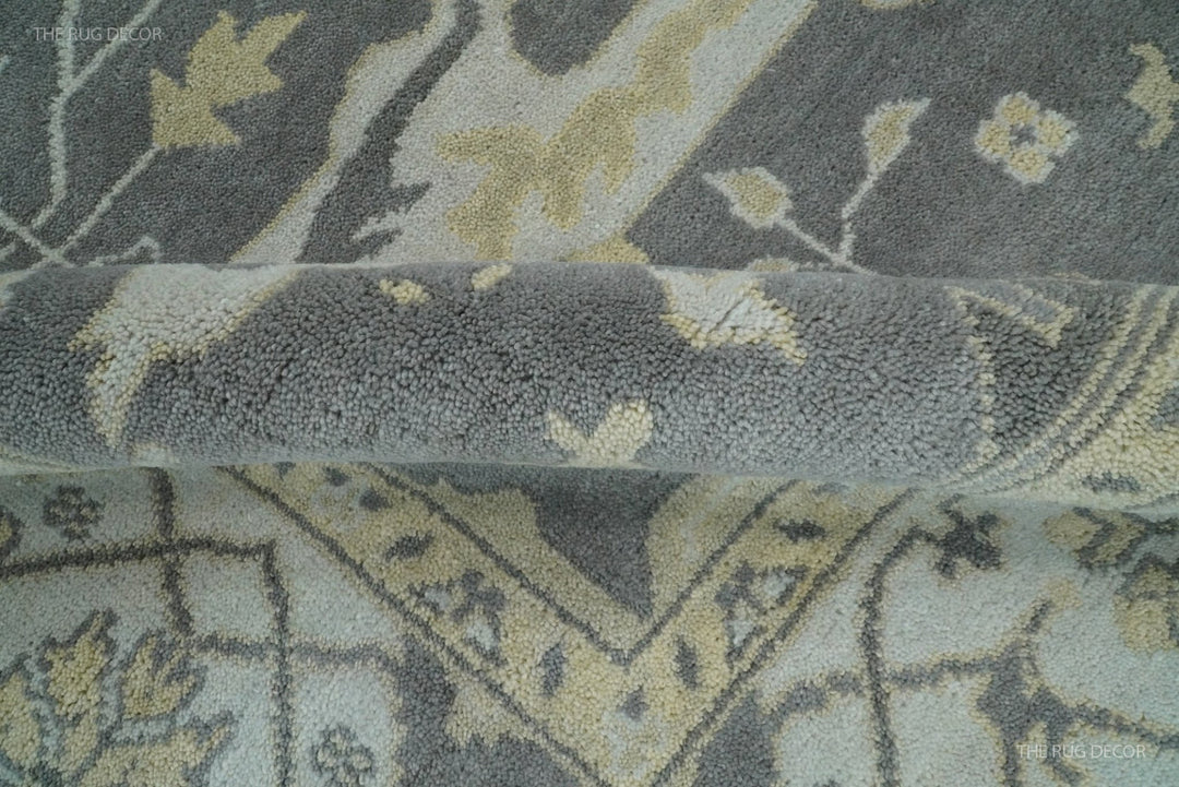 Close-up section of vintage Oushak-style wool rug with gray and ivory motifs