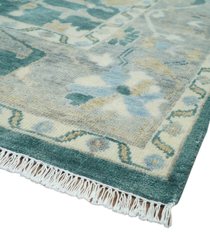 Teal and beige Oushak wool rug corner with border details and short fringed edge.