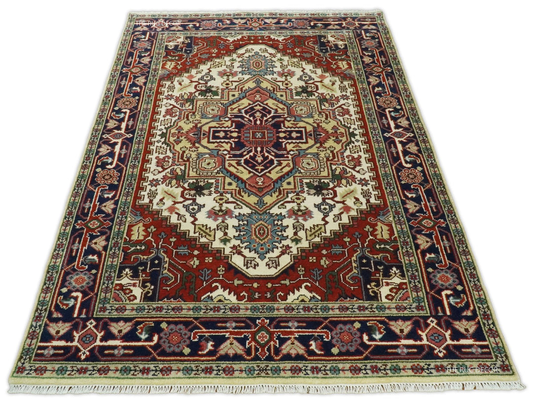 Hand-knotted wool area rug with ivory field, maroon-red border, and navy geometric trim