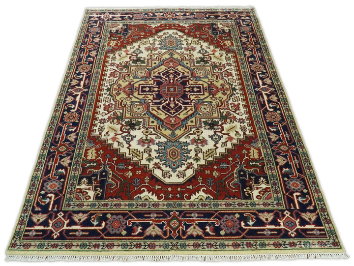 Hand-knotted wool area rug with ivory field, maroon-red border, and navy geometric trim