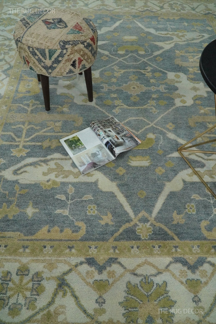 Gray and beige Oushak rug with a floral medallion and wide border