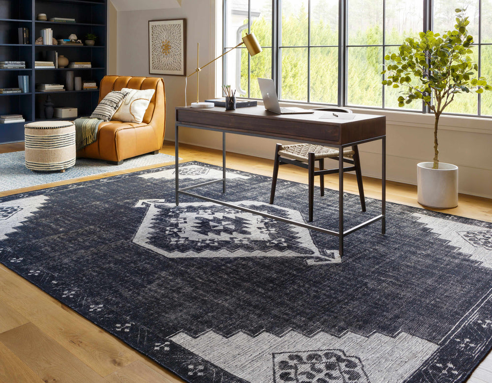 Black and ivory traditional area rug with geometric border, laid flat on floor