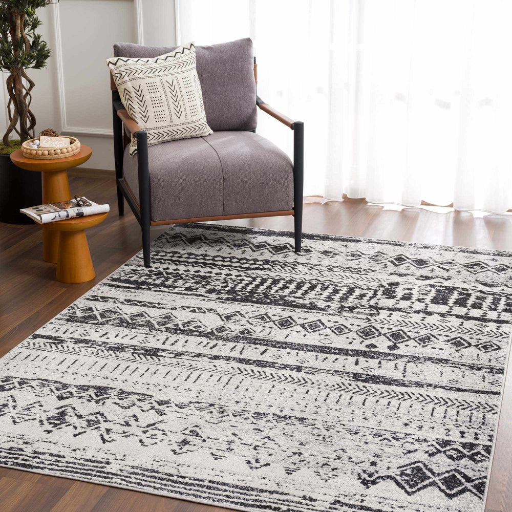 Ivory-and-black geometric area rug with bold tribal motifs on floor