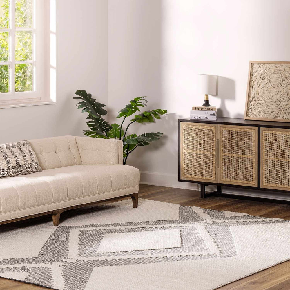 Ivory and gray boho area rug with geometric motif and stitched borders