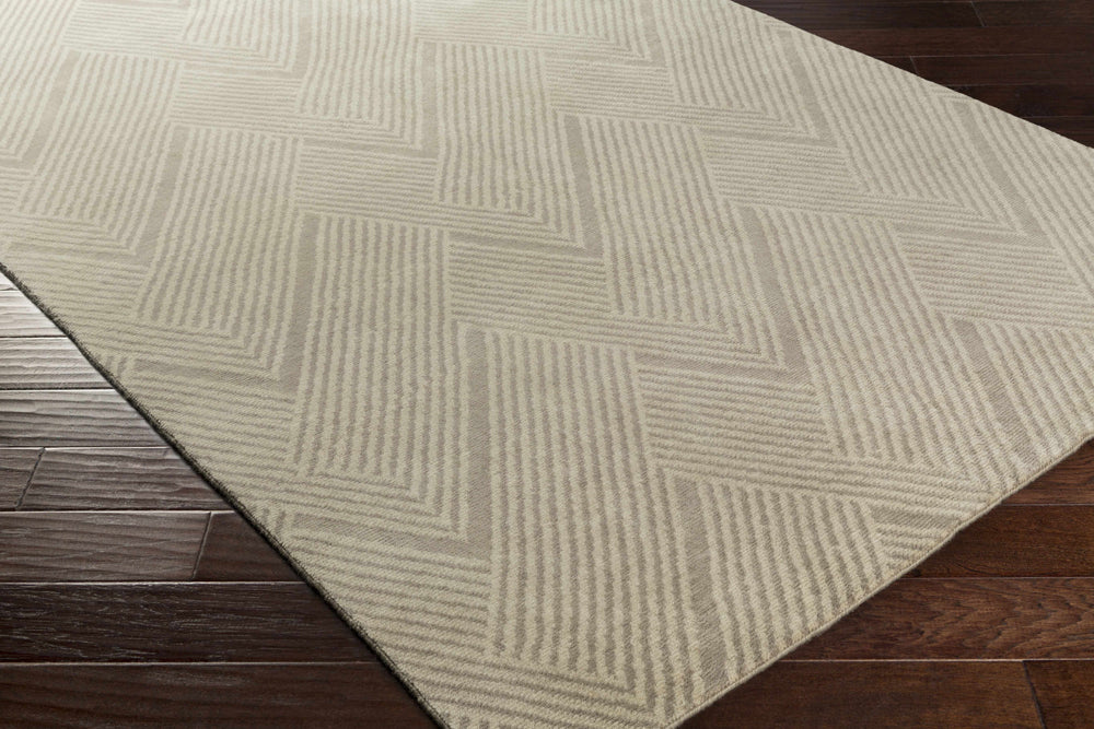 Beige area rug with diamond and chevron geometric design, angled view