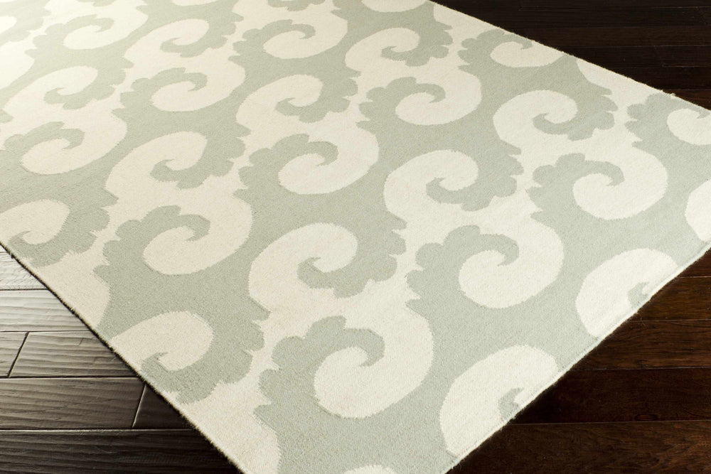 Ivory and gray area rug shown at an angle with abstract swirl pattern