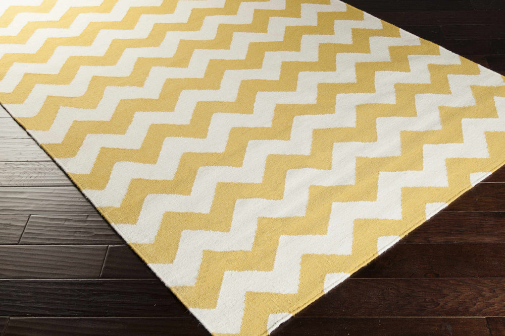 Chevron hand-woven wool area rug in mustard and cream, angled view