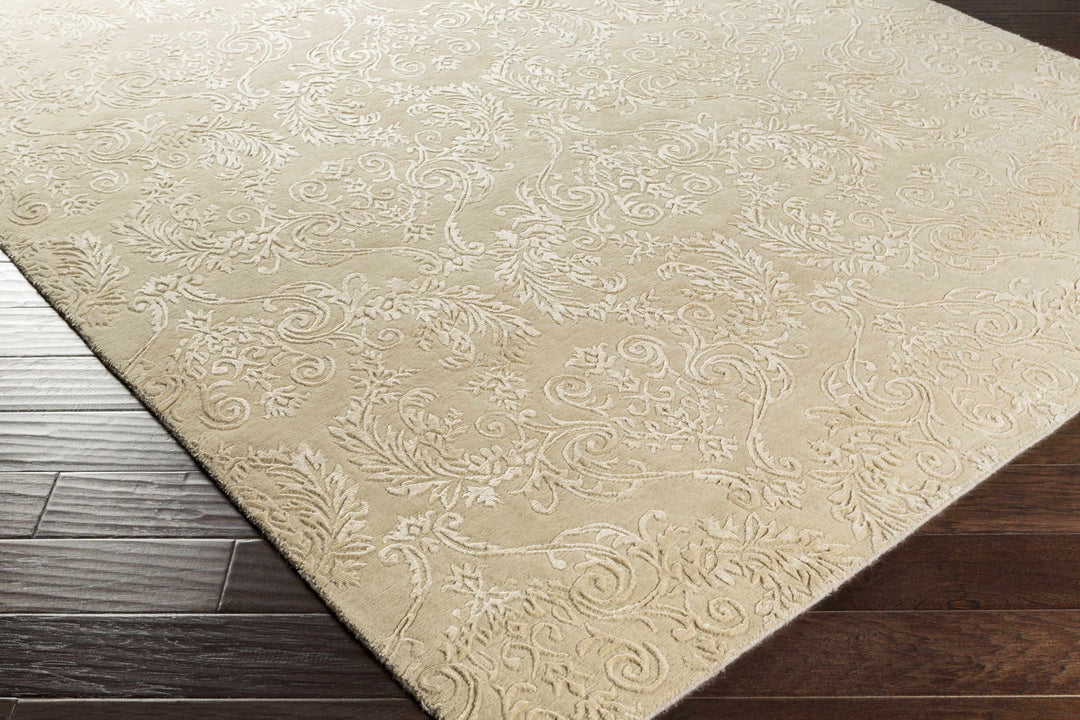 Beige traditional area rug corner view with raised scroll and floral motifs