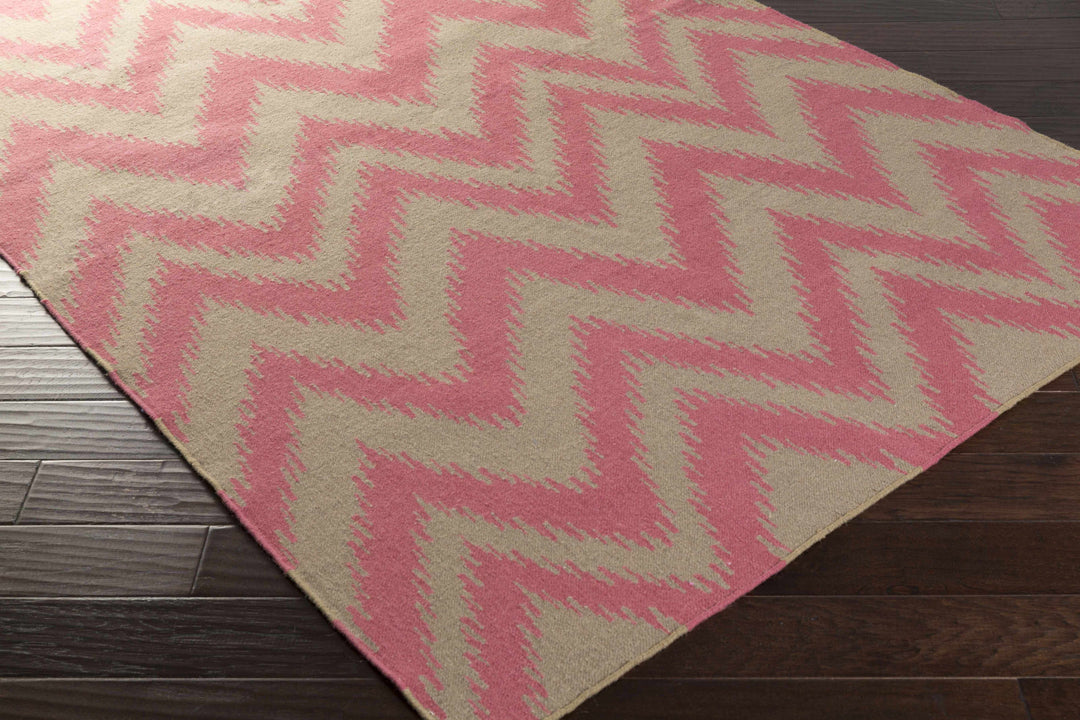 Pink and cream chevron hand-woven area rug, angled view of zigzag geometric design