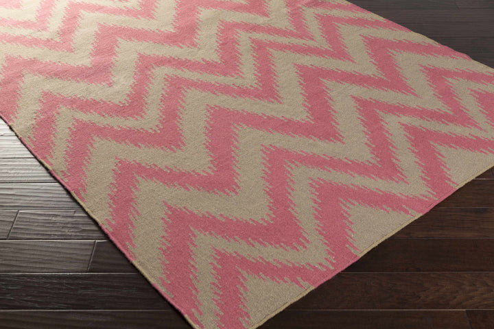 Pink and cream chevron hand-woven area rug, angled view of zigzag geometric design