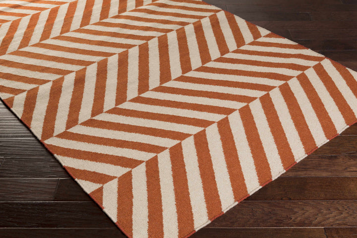 Orange and cream chevron area rug, corner view with repeating geometric pattern
