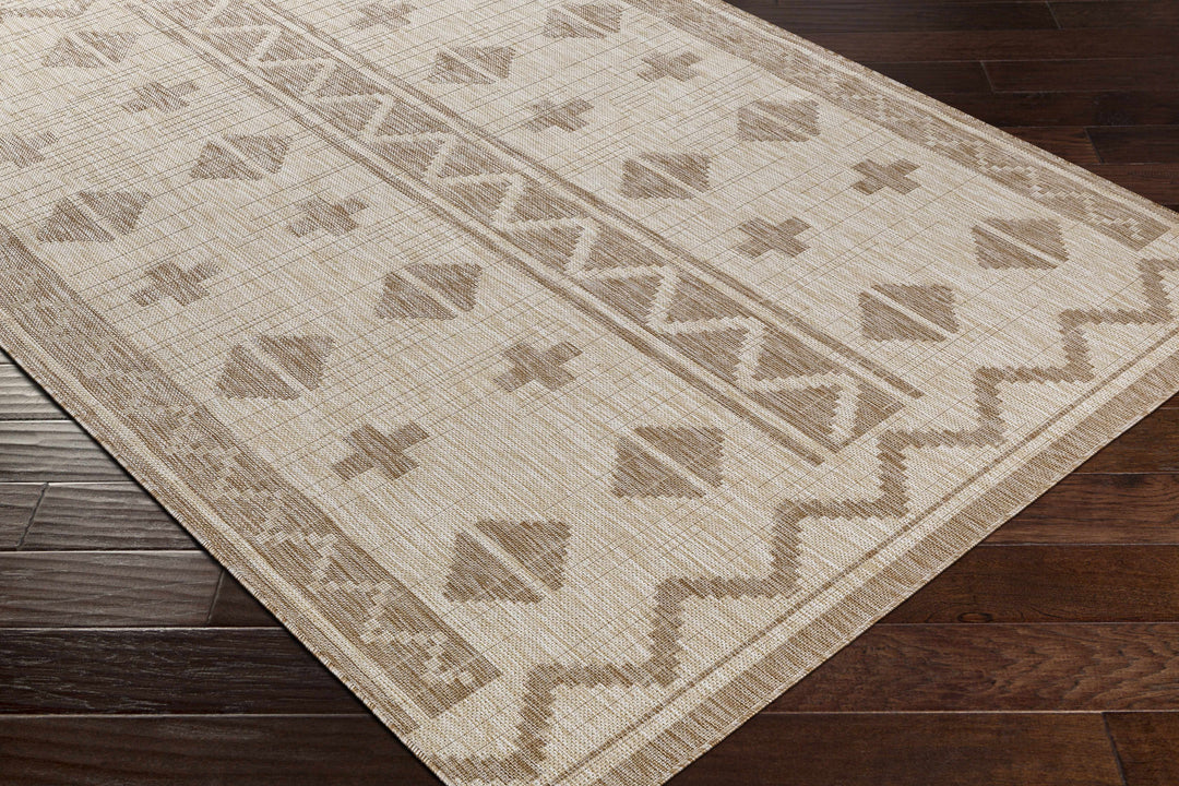 Beige modern area rug corner close-up with geometric shapes and border