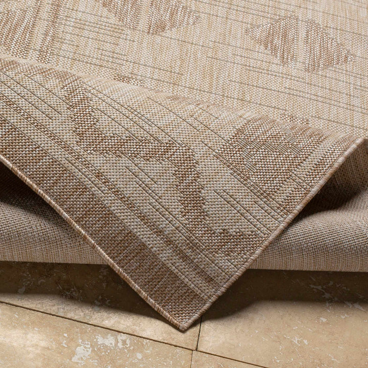 Beige modern area rug edge view with textured weave and geometric lines
