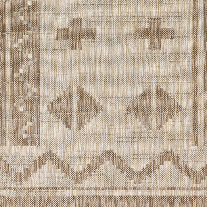 Beige modern area rug close-up with cross and diamond geometric motifs